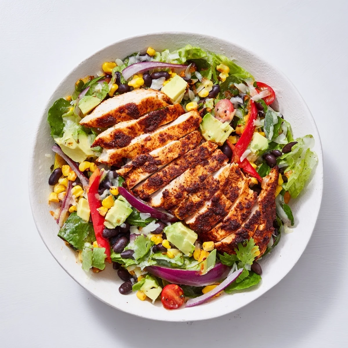 A refreshing bowl of Southwest Chicken Salad, with avocado, black beans, and a flavorful lime dressing.