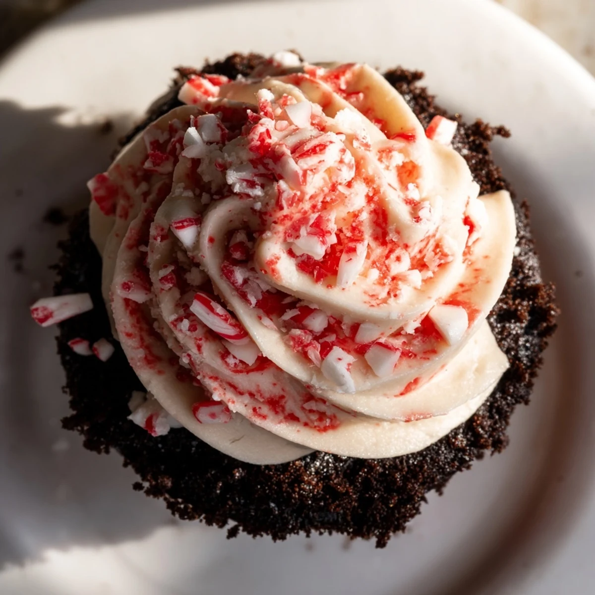 A close-up shows fudgy Chocolate Peppermint Swirl Cupcakes with red-swirled frosting and peppermint candies, ideal for Christmas parties.