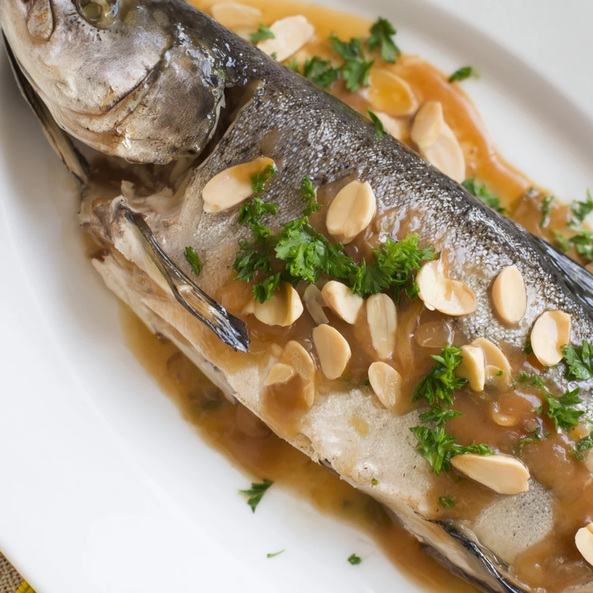Sizzling almond butter sauce with toasted slices is poured over freshly baked trout fillets.