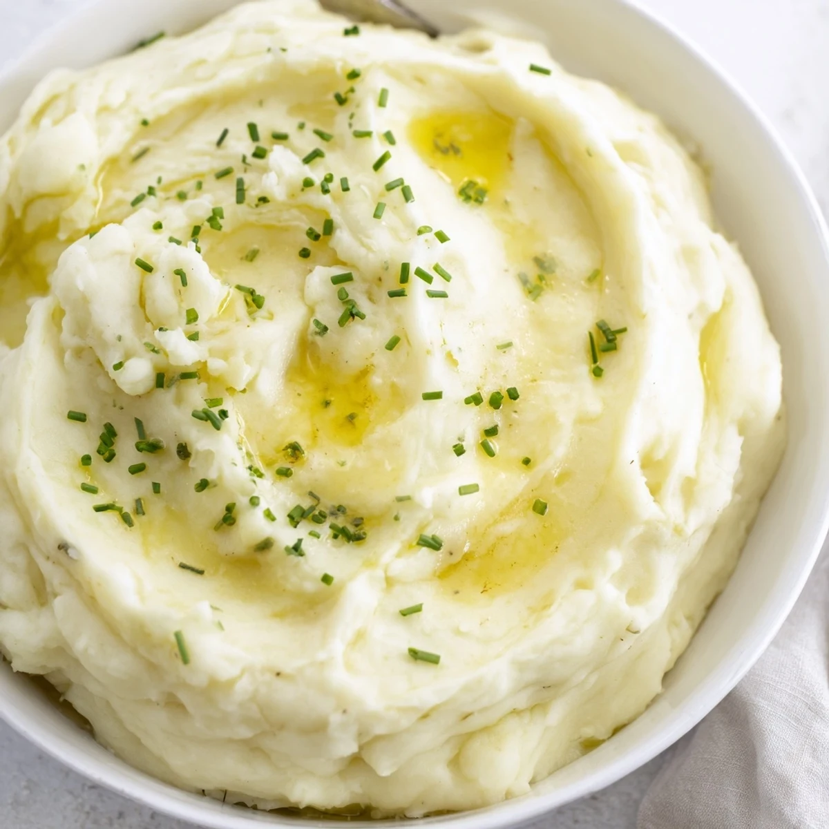 Golden roasted garlic cloves blended into fluffy Roasted Garlic Mashed Potatoes, garnished with parsley for a fresh finish.