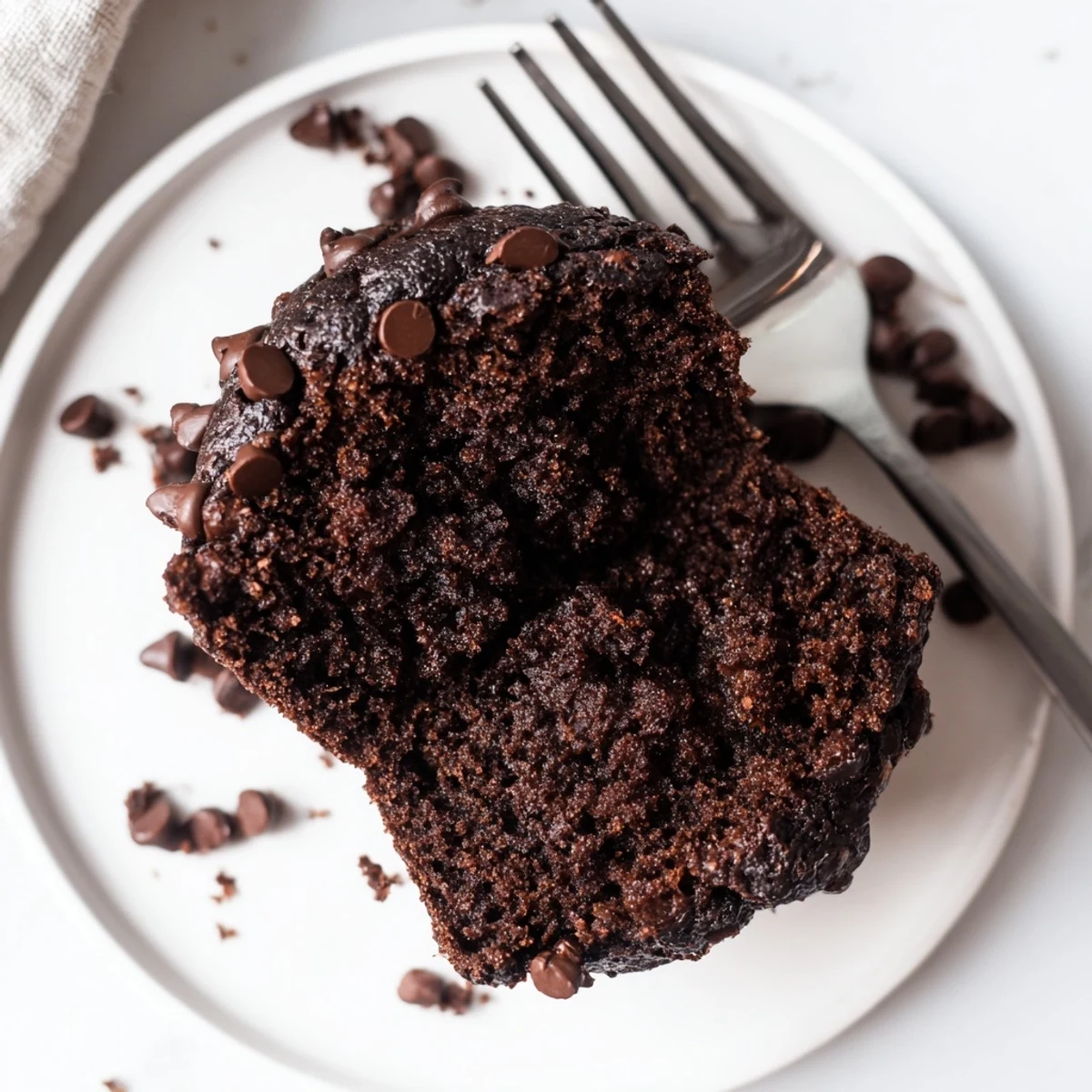 A stack of moist Chocolate Banana Muffins with chocolate chips, perfect for a sweet breakfast or afternoon treat.