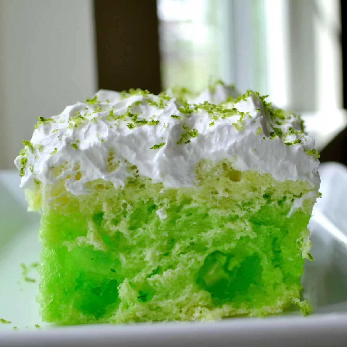 Easy St. Patricks Day Lime Poke Cake served chilled, showcasing the moist crumb and refreshing citrus flavor perfect for a spring celebration.