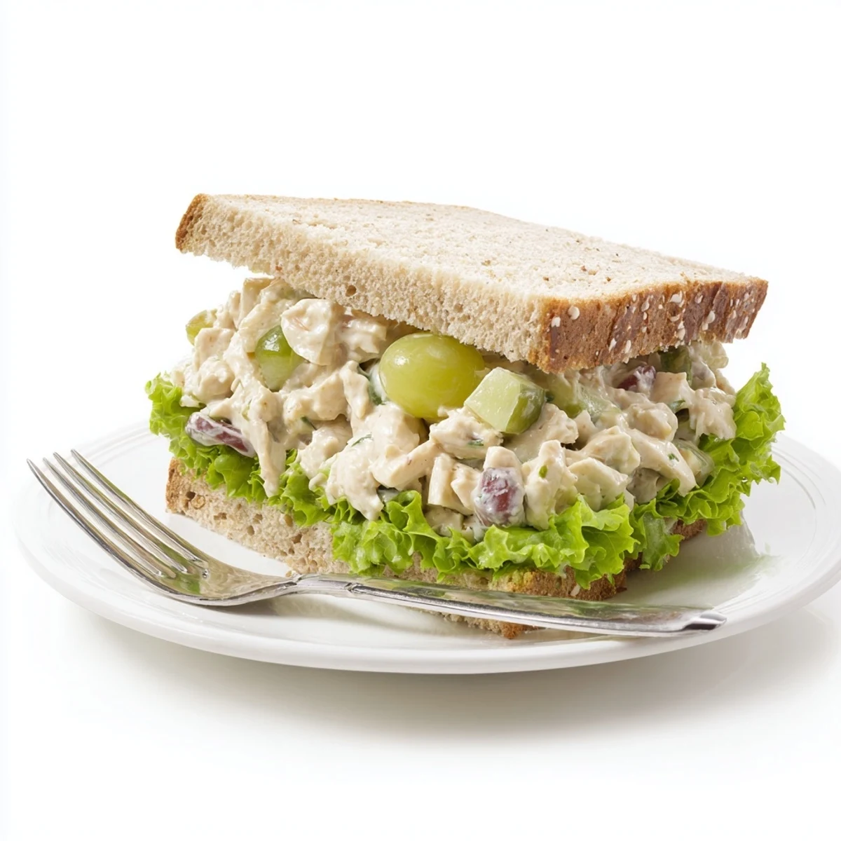 Creamy chicken salad sandwich with juicy grapes and crunchy celery on toasted bread, garnished with fresh lettuce.  