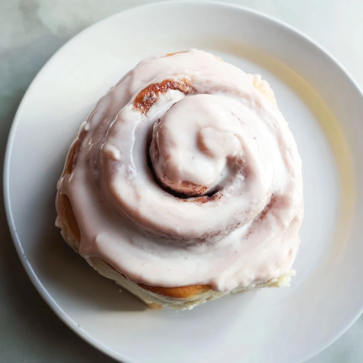 Freshly baked Sweetheart Cinnamon Rolls topped with pink cream cheese icing, perfect for a romantic breakfast or brunch.  