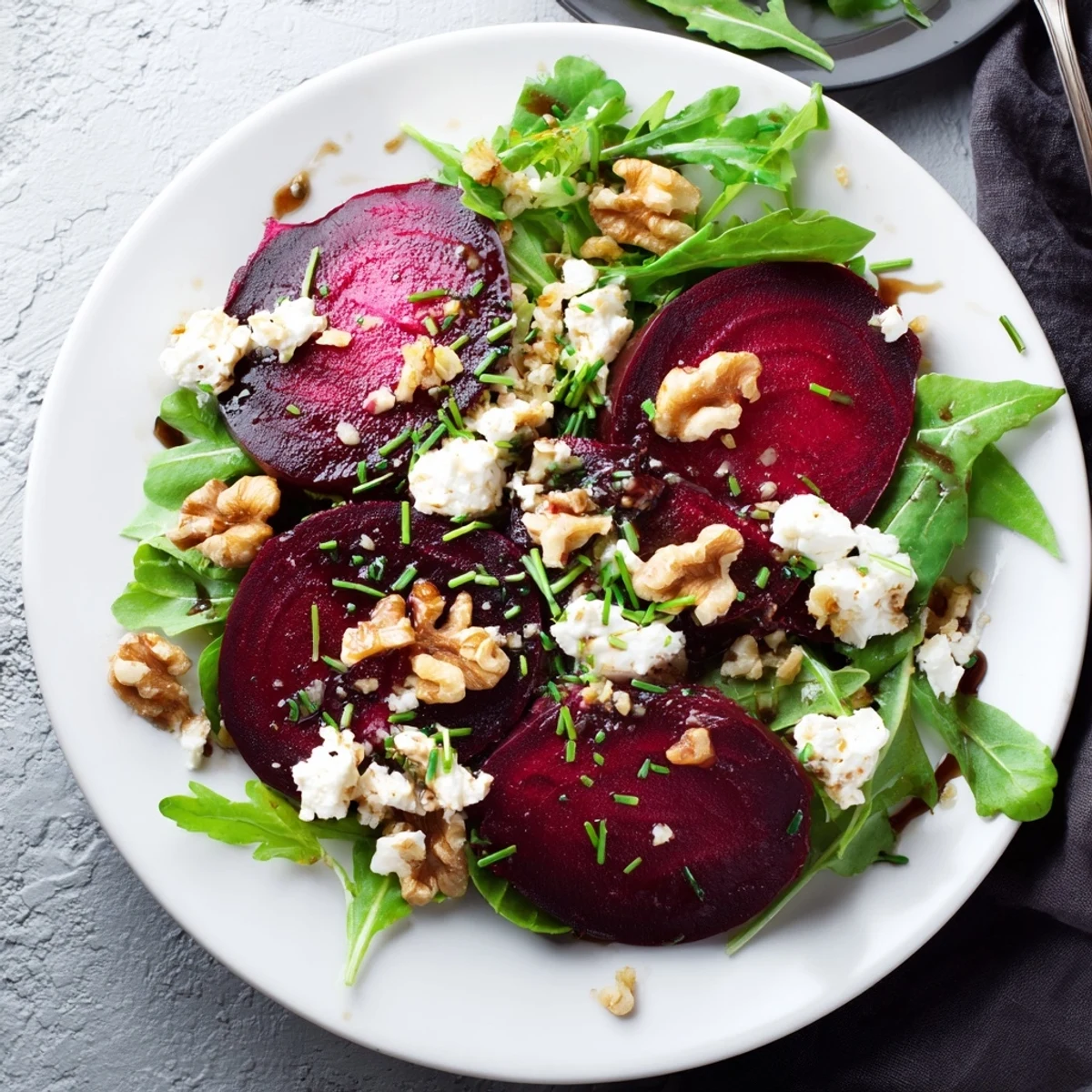 Earthy, jewel-toned beet wedges beside crumbled goat cheese and walnuts, ready to drizzle with honey-balsamic dressing.