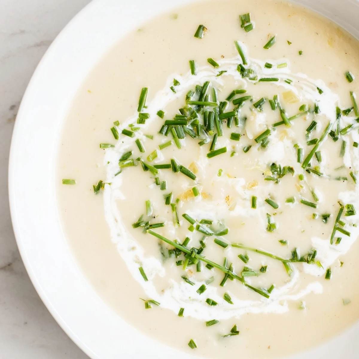 Steaming bowl of Creamy Potato Soup with Chives, served with crusty bread for a comforting vegetarian dinner.