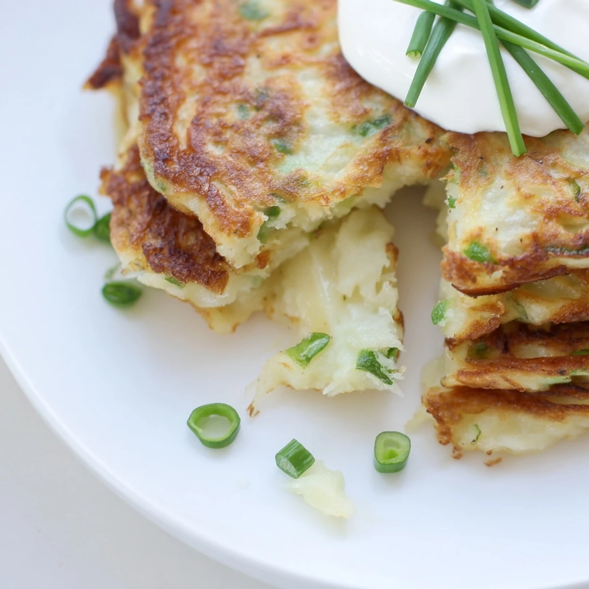 Golden-brown Irish Boxty Potato Pancakes with Scallions sizzling in a skillet, ready for a hearty breakfast.