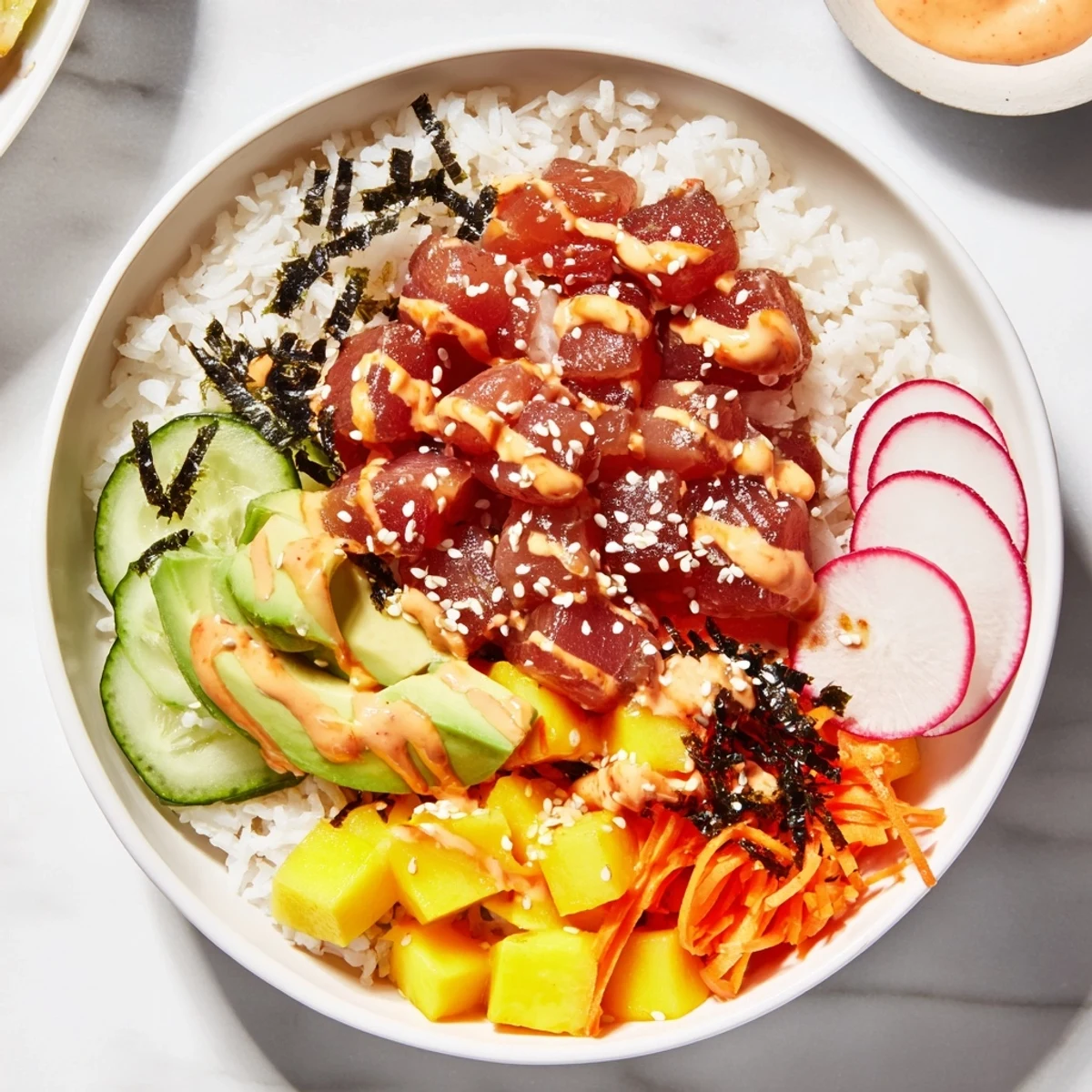 Spicy Tuna Poke Bowl with Mango and Avocado served over seasoned sushi rice, garnished with creamy avocado and a drizzle of spicy mayo.