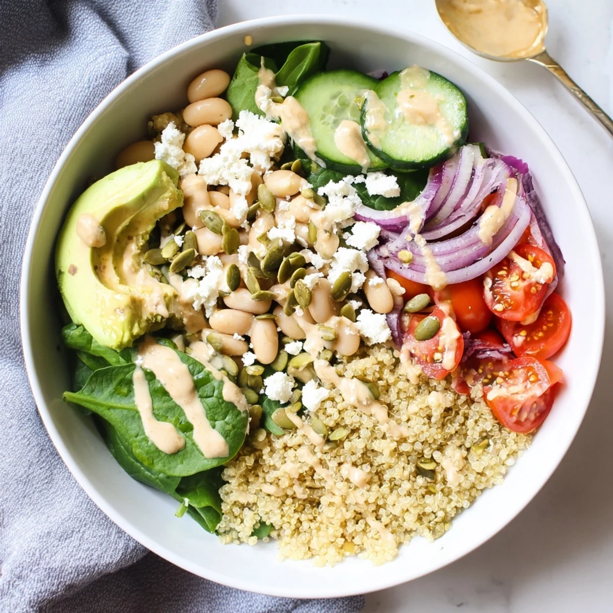 A vibrant Spinach & White Bean Ultimate Protein Power Bowl topped with creamy avocado and toasted pepitas.