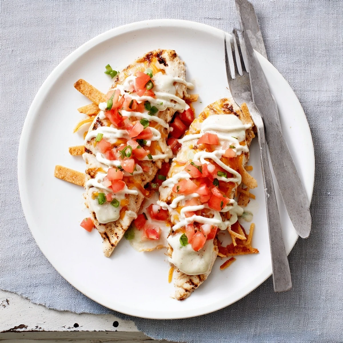 A vibrant plate of Fiesta Lime Chicken with melted cheese and pico de gallo, served alongside warm tortilla strips.