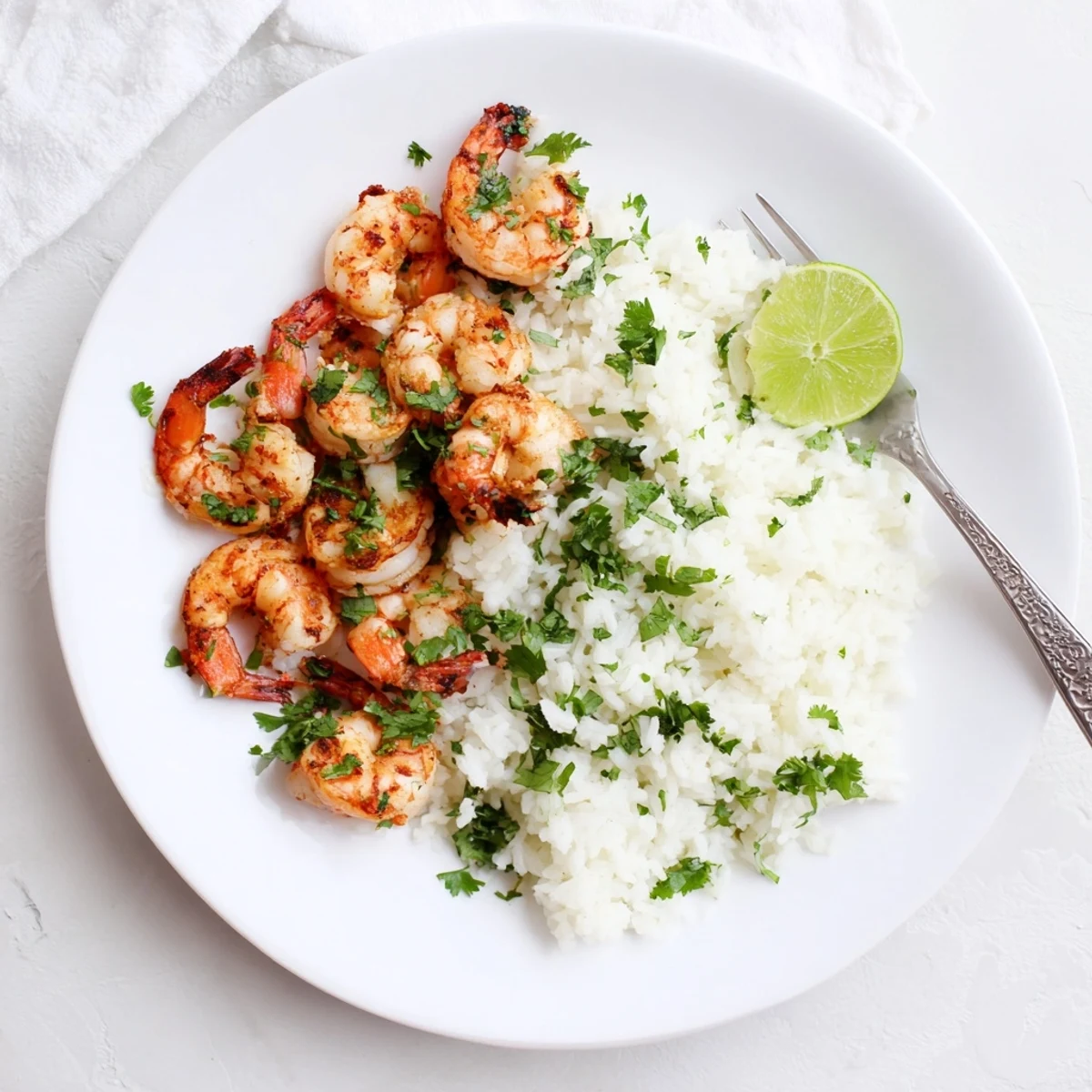 Juicy shrimp in spicy lemongrass sauce served over fluffy coconut rice with cilantro garnish.