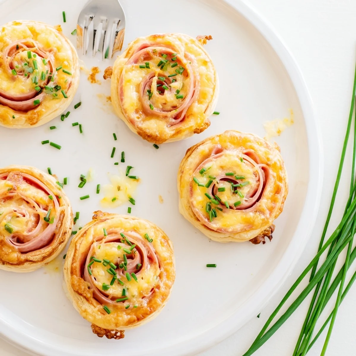 Close-up of Ham and Cheese Pinwheels sliced open to show the melty Swiss cheese and ham wrapped in crisp puff pastry.