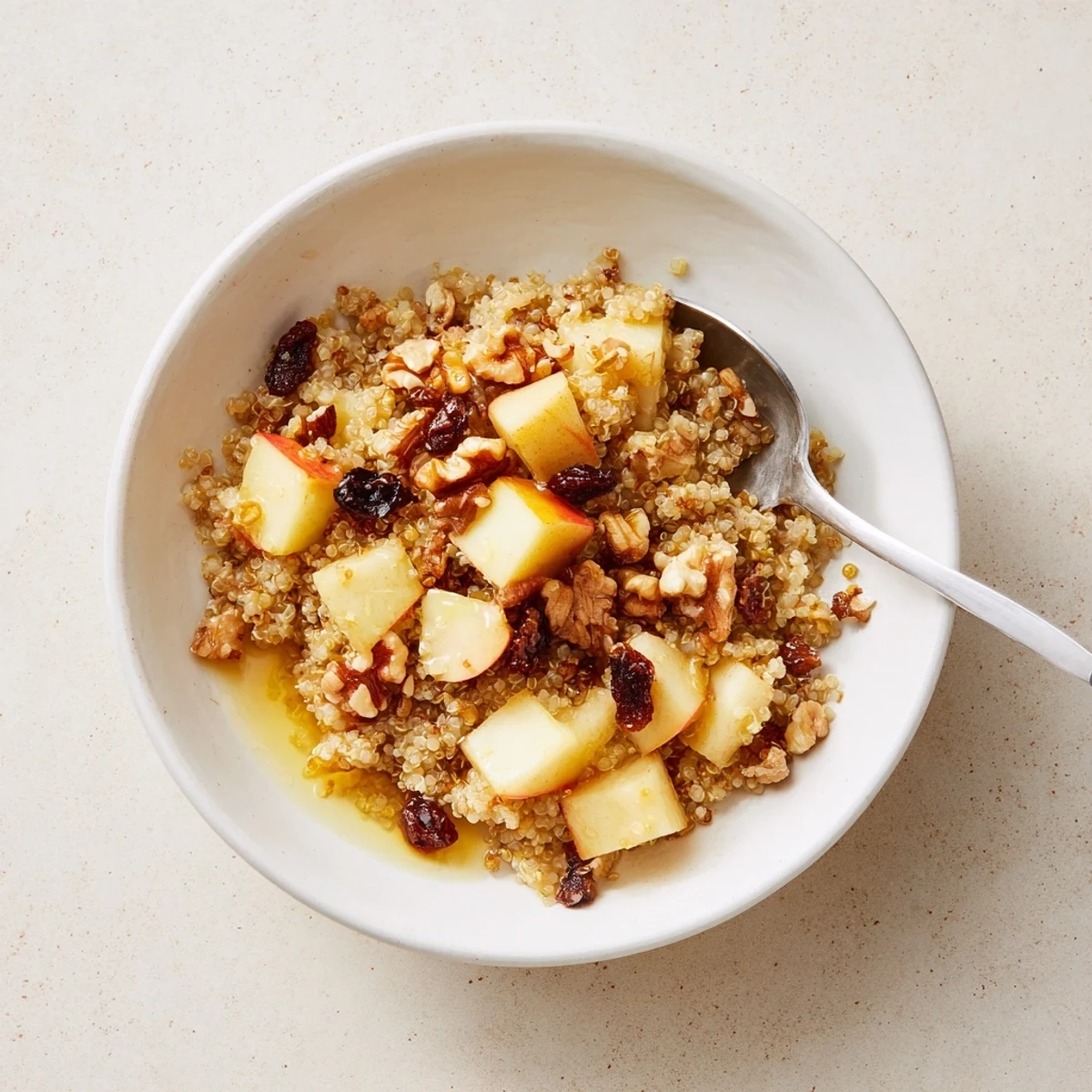 A warm bowl of Healthy Quinoa Apple Breakfast topped with crunchy walnuts and sweet apple slices.