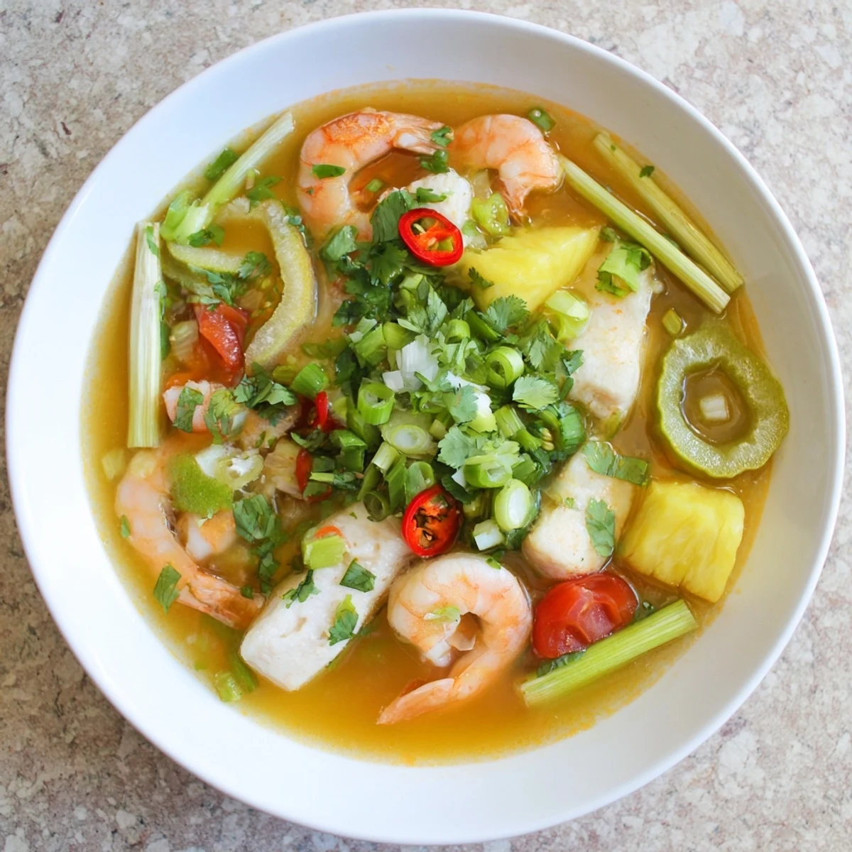 Serving suggestion for Vietnamese Canh Chua soup with steamed jasmine rice on the side, featuring colorful vegetables and herbs.