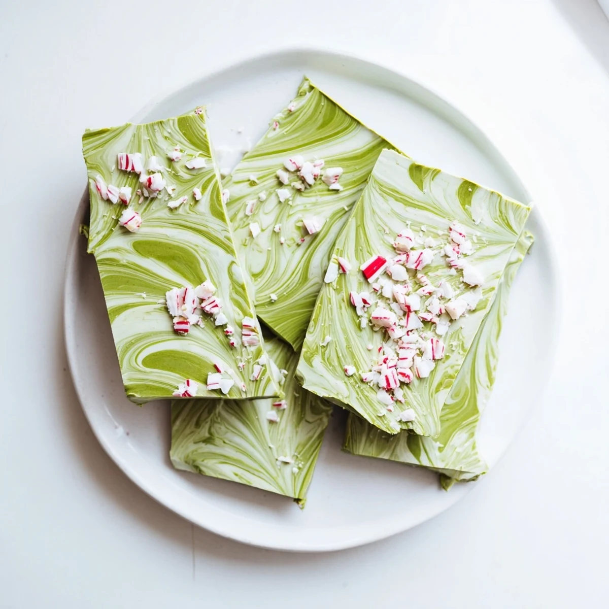 Matcha Peppermint Bark pieces displayed on a rustic wooden board, ready to be gifted or served with hot cocoa.