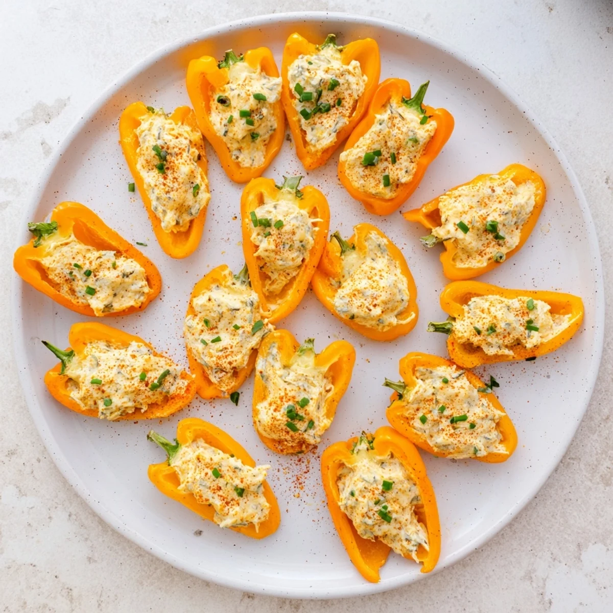 Colorful roasted mini peppers filled with savory cream cheese blend garnished with fresh green chives
