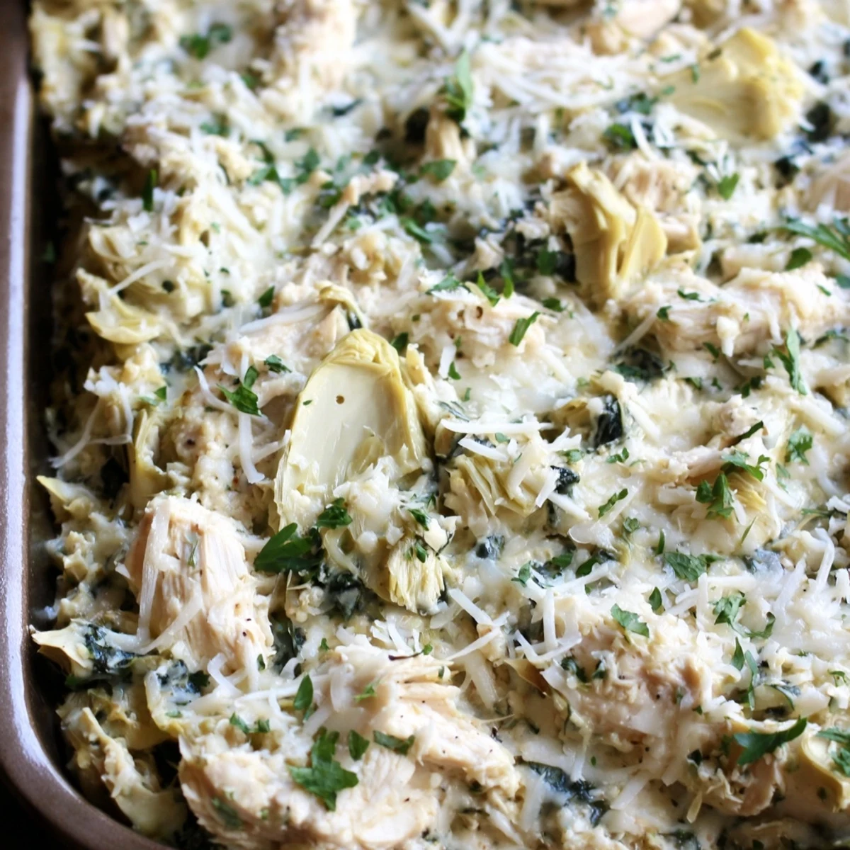 Creamy spinach and artichoke chicken casserole topped with golden melted mozzarella cheese