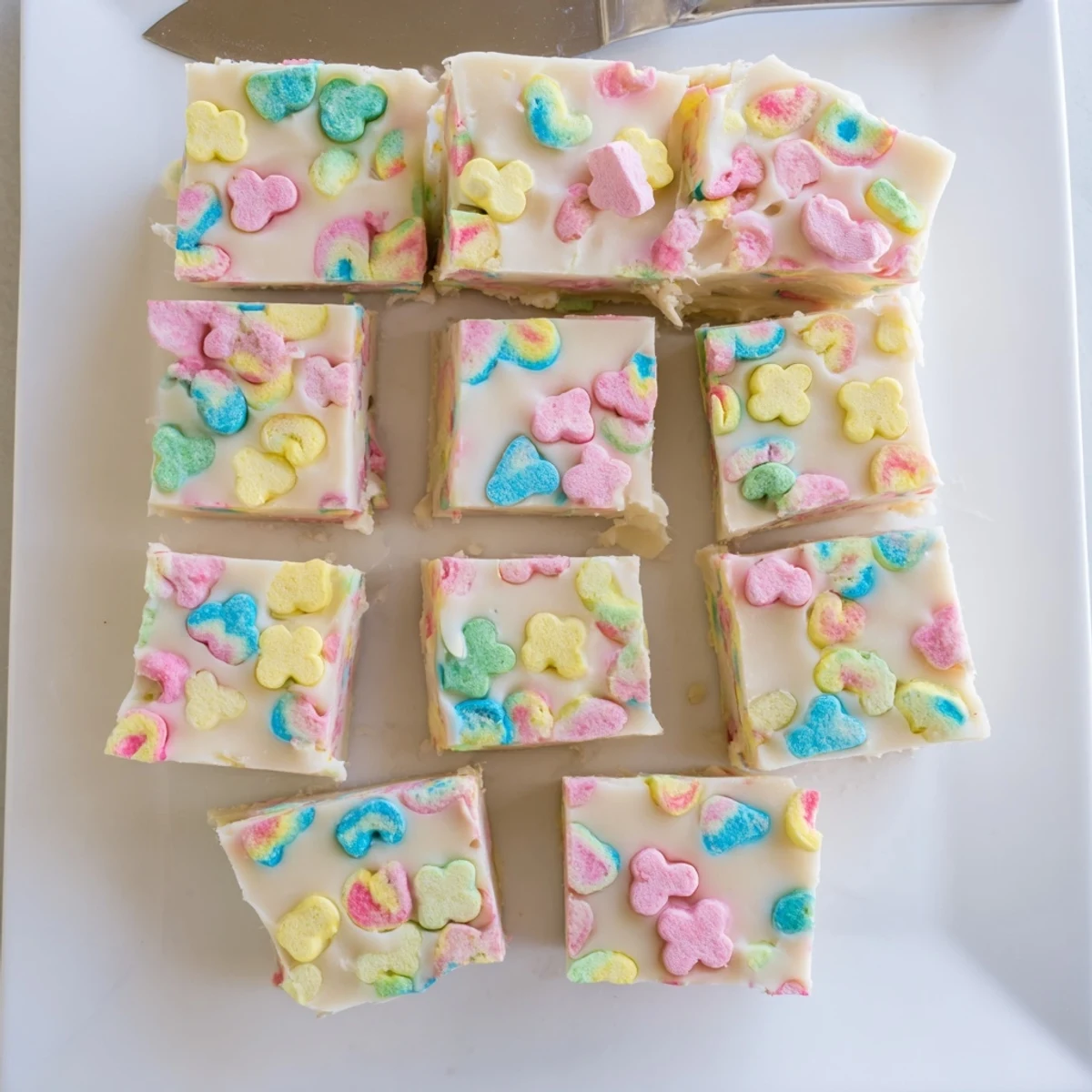 Square slice of Easy Lucky Charms Fudge showing swirled marshmallows against smooth white chocolate background.