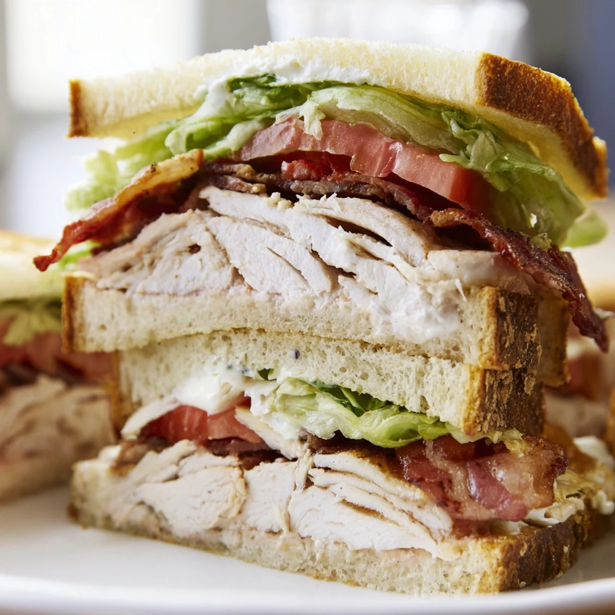 Classic chicken club sandwiches stacked with crispy bacon lettuce tomato on toasted bread