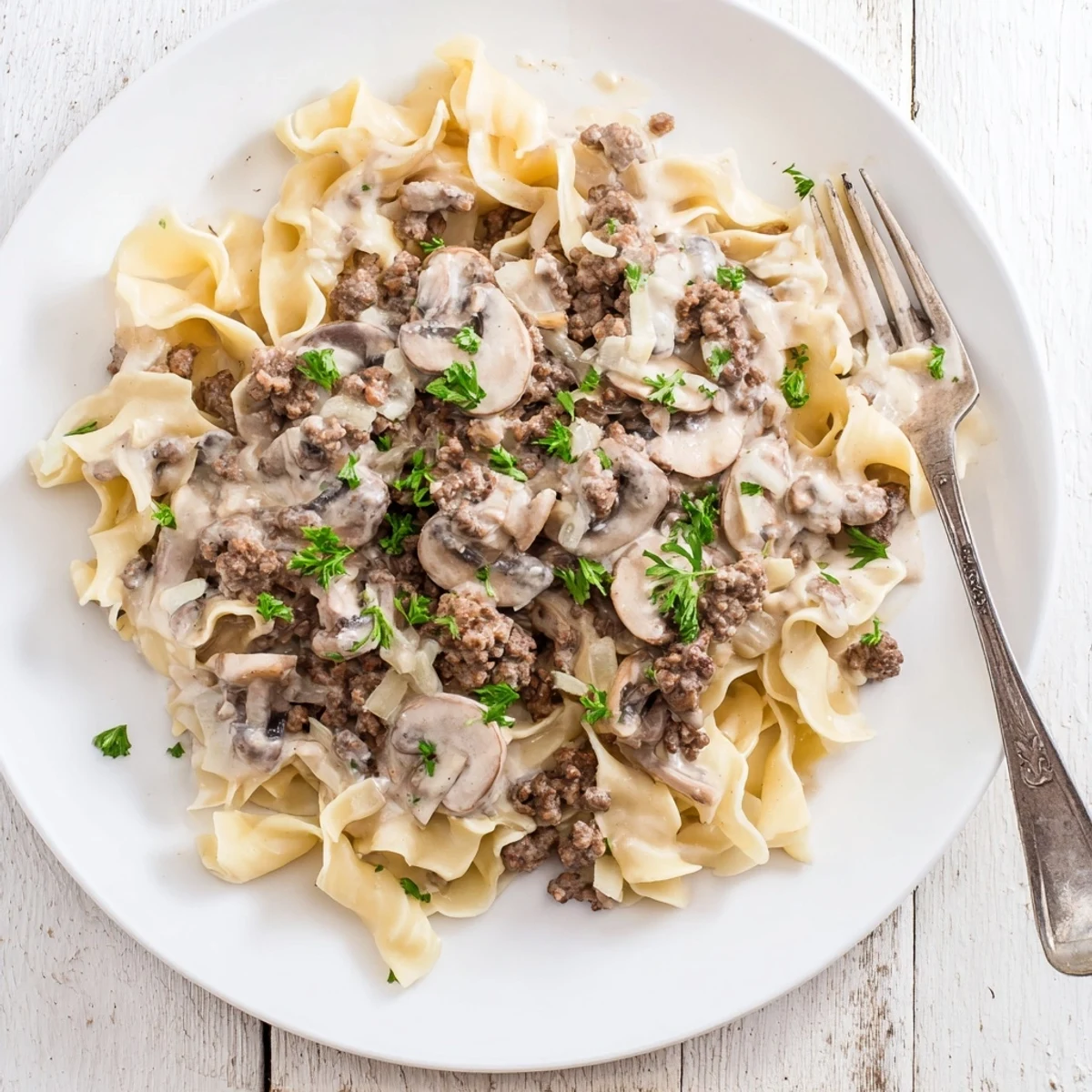 Creamy hamburger stroganoff with ground beef and mushrooms over tender egg noodles