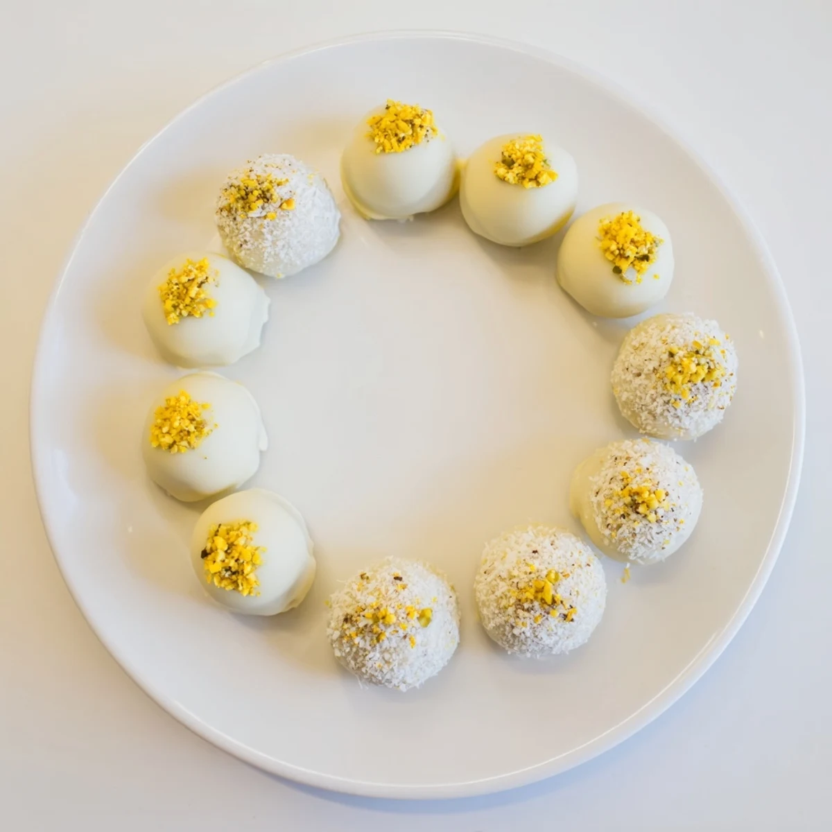 Creamy mango truffles coated in white chocolate and sprinkled with dried mango bits