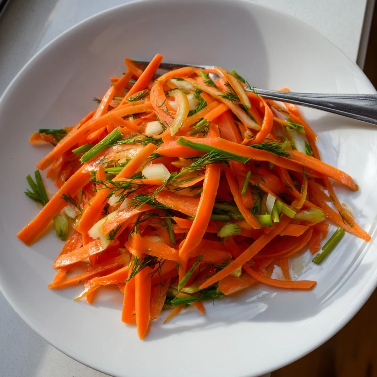 Crisp marinated lemon dill carrot salad glistening with bright citrus dressing in a serving bowl
