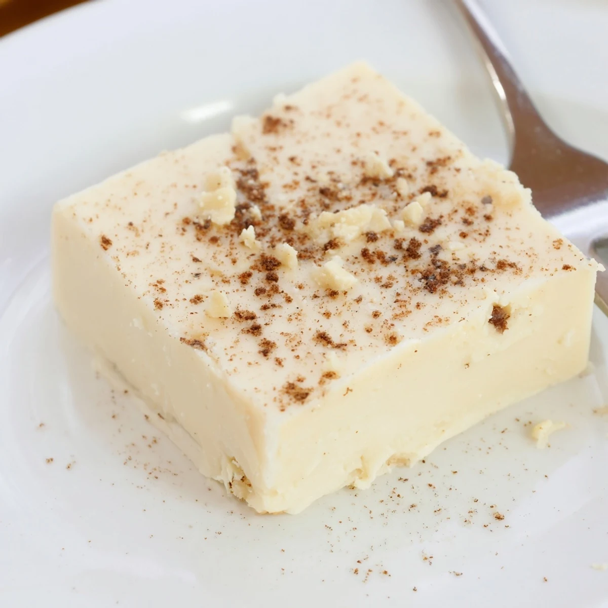 Slices of Eggnog Fudge stacked on a plate, velvety and fragrant  