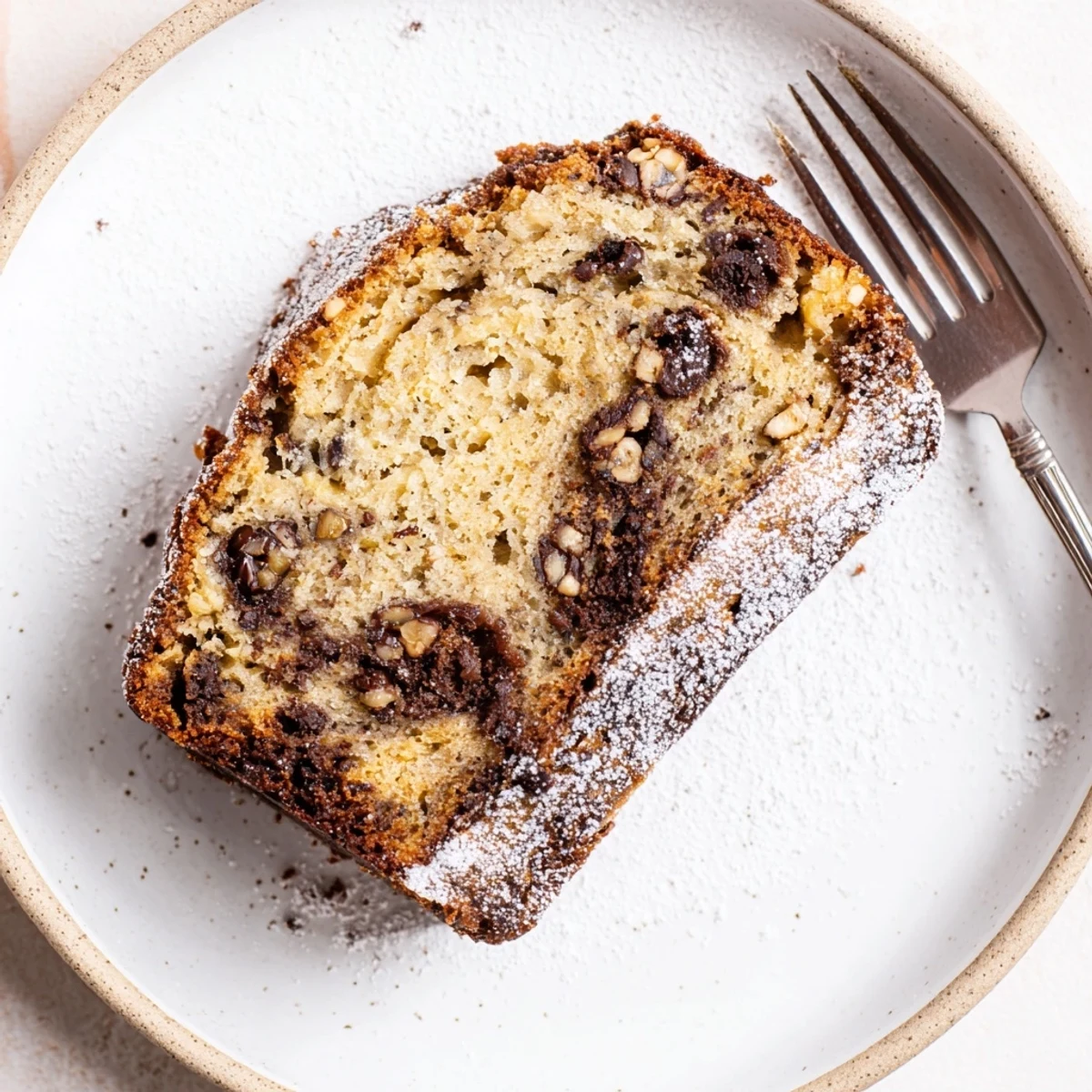 Slice of Banana Bread Cake Recipe served with melting vanilla ice cream.