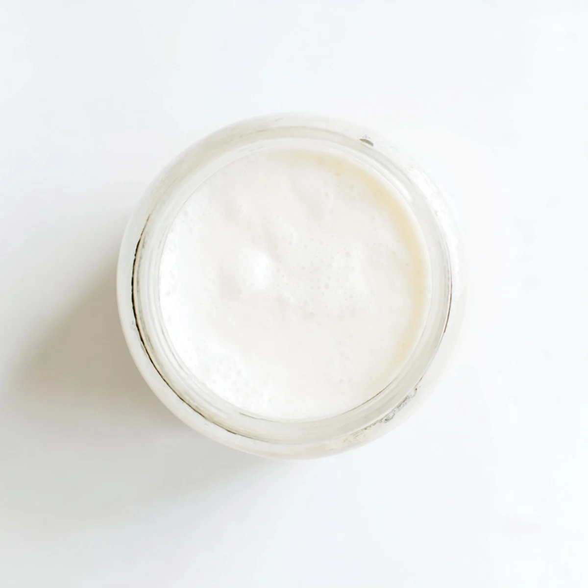 Vegan homemade coconut milk recipe in mason jar with kitchen towel nearby