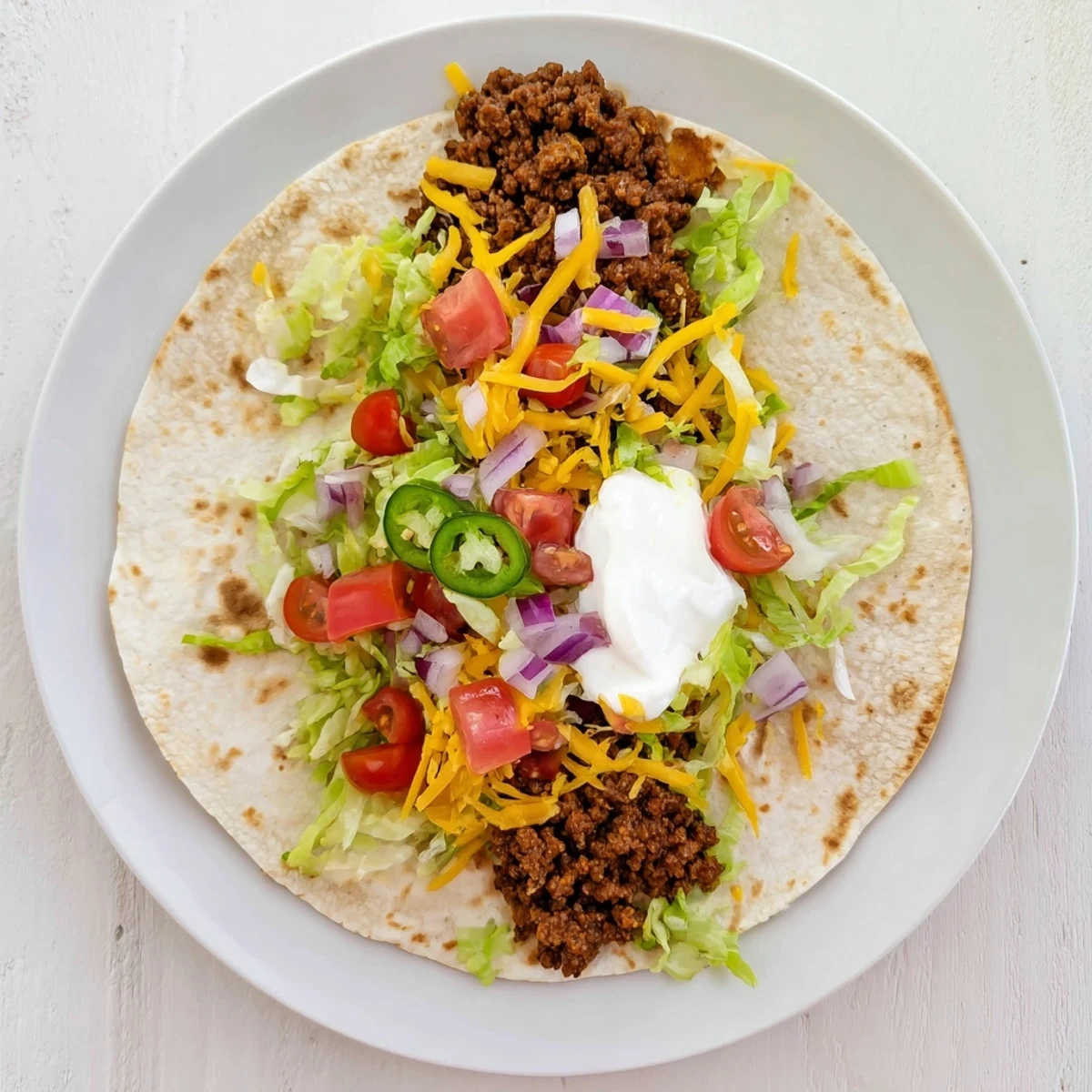 Sizzling Blackstone smash burger tacos featuring juicy seasoned beef patties with bubbly cheese and crisp tortilla edges