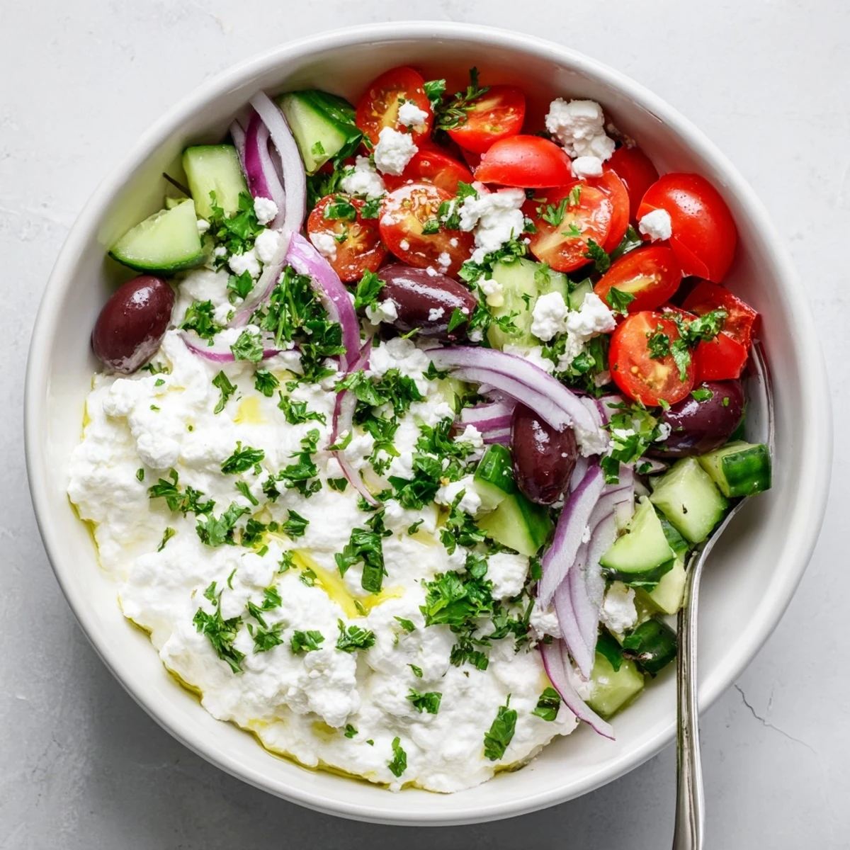 Protein-packed Greek salad cottage cheese bowl topped with colorful fresh vegetables and tangy olives