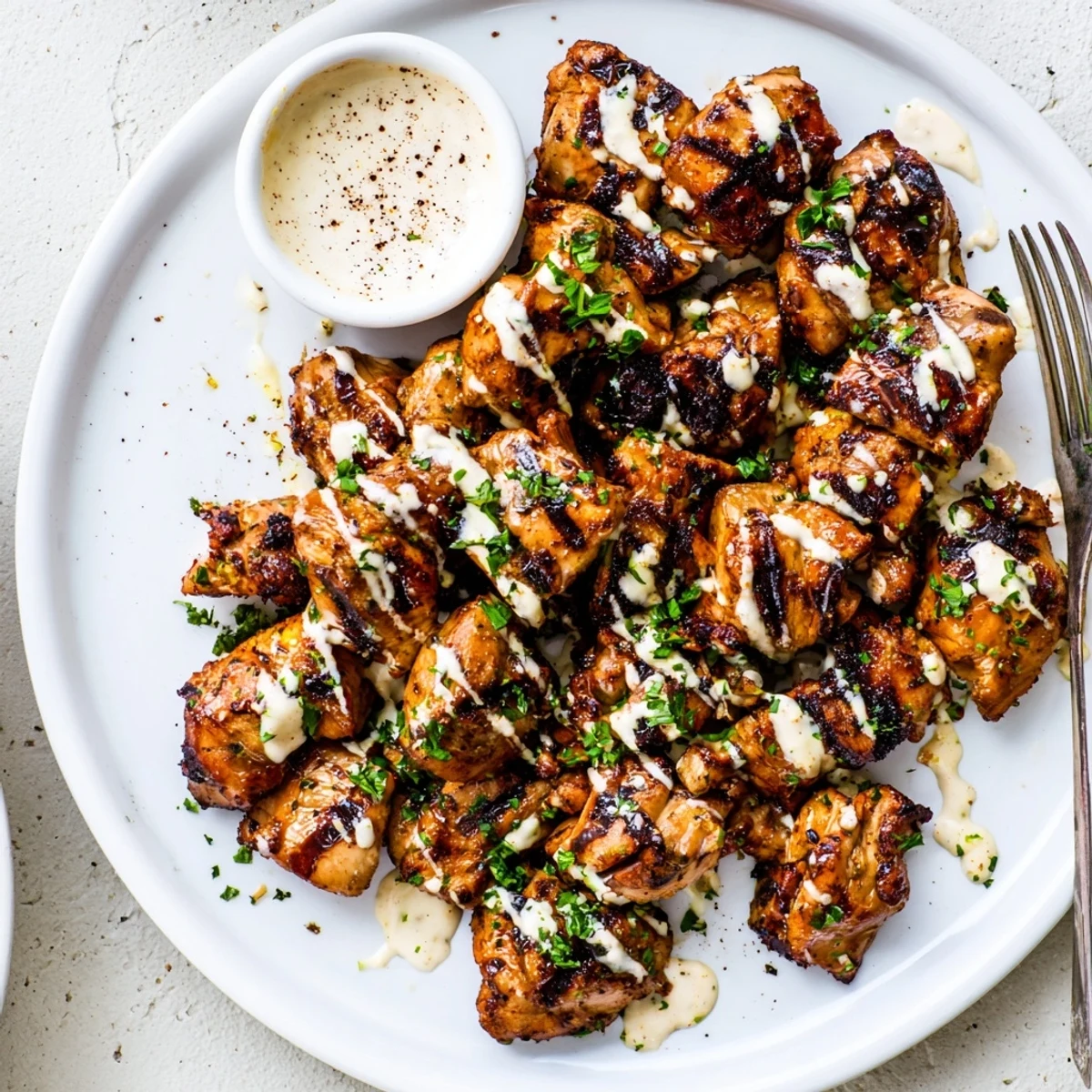 Grilled Chicken Bites With Creamy Garlic Sauce piled next to crisp veggie sticks