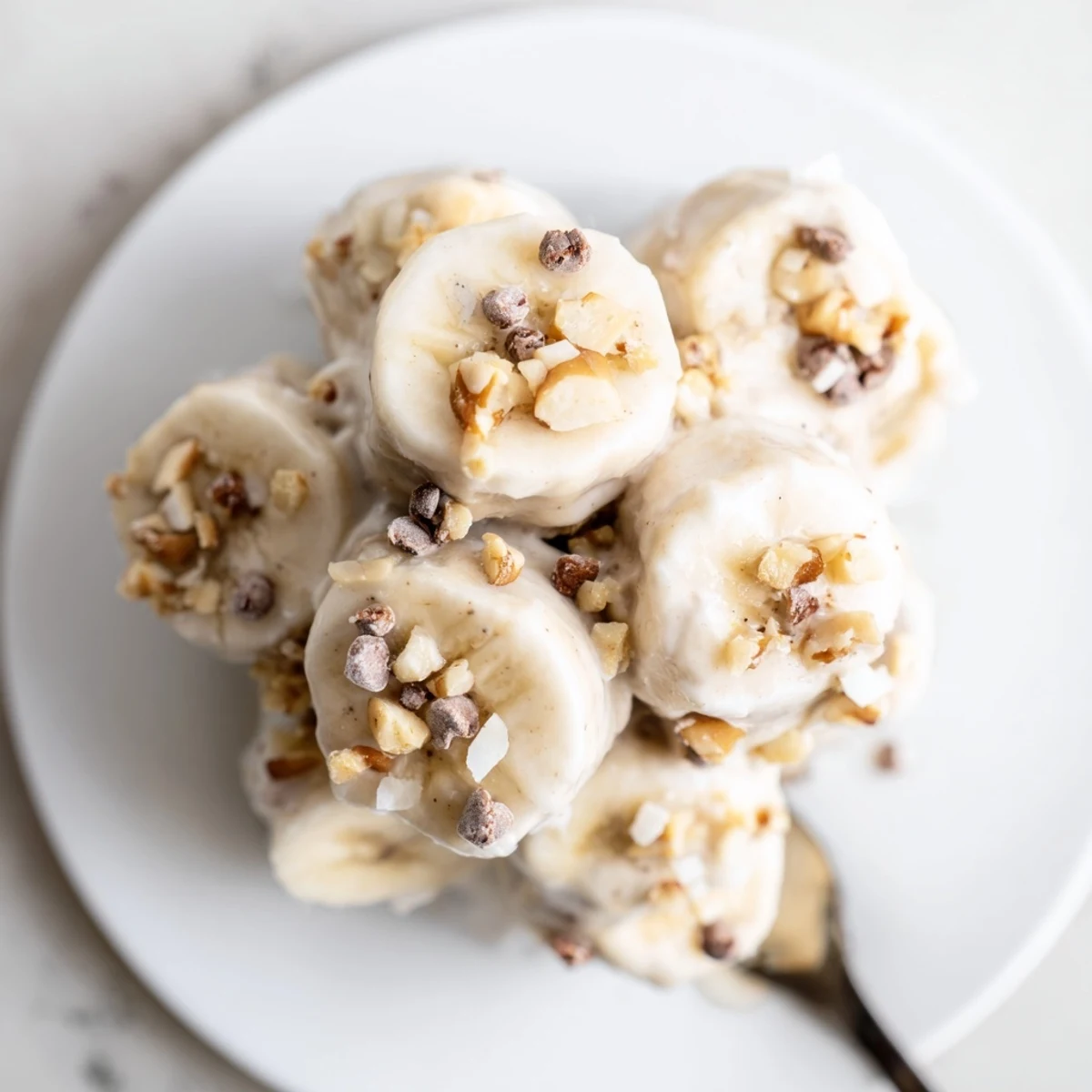 Frosty Frozen Banana Yogurt Bites dotted with mini chocolate chips, ready to eat