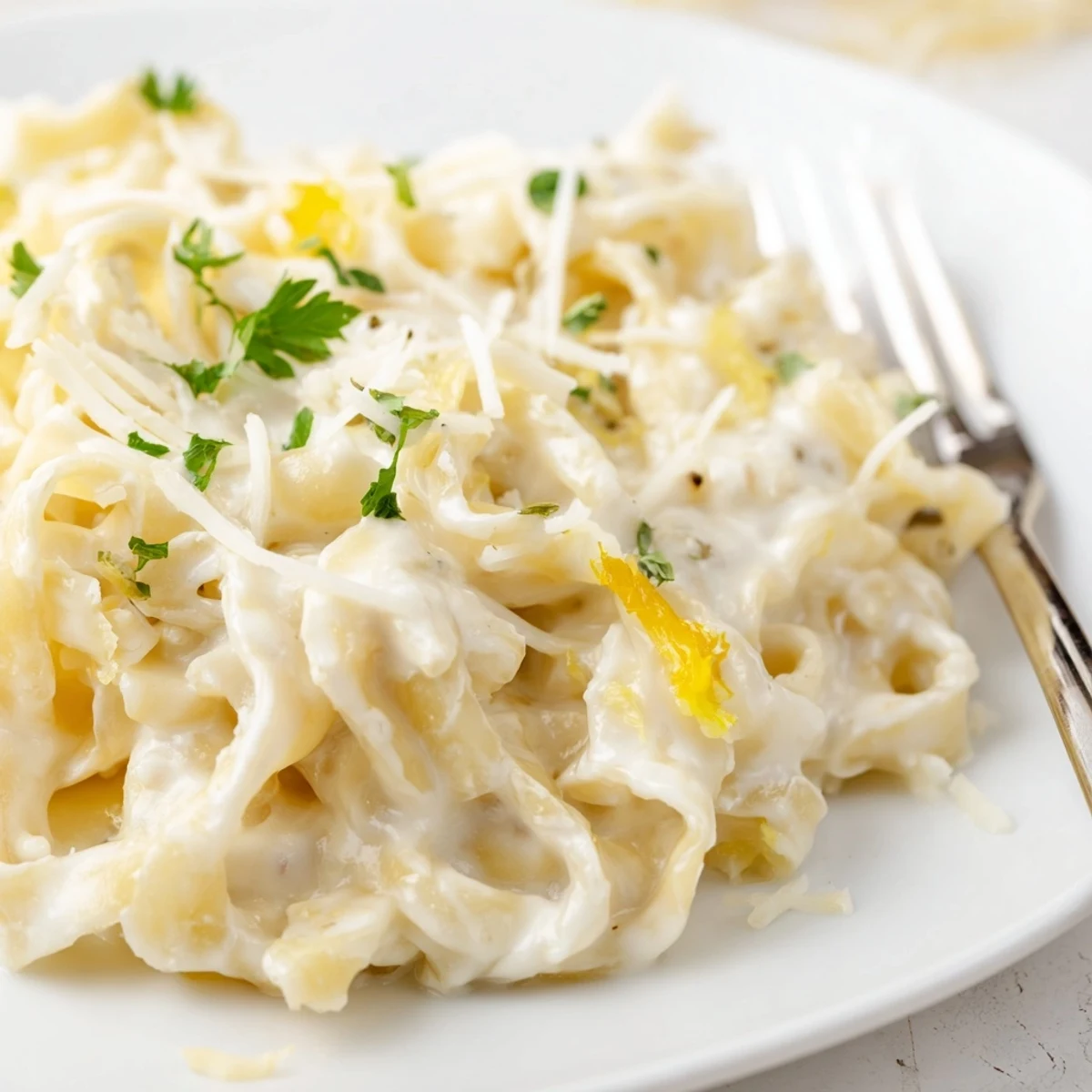 Golden creamy cafeteria noodles coated in rich Parmesan sauce with fresh parsley garnish