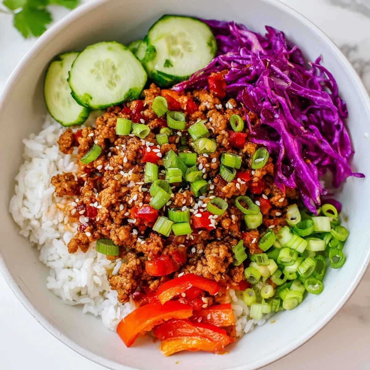 Colorful ground turkey rice bowls topped with crisp vegetables, sesame seeds, and fresh cilantro