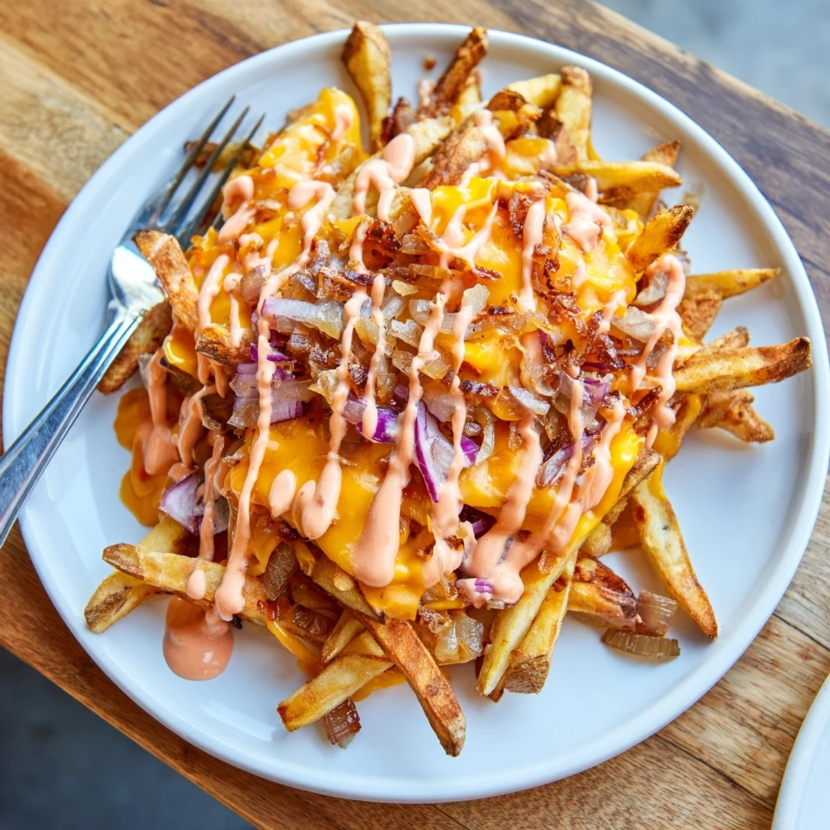 Golden Animal Style Fries topped with caramelized onions and creamy drizzle